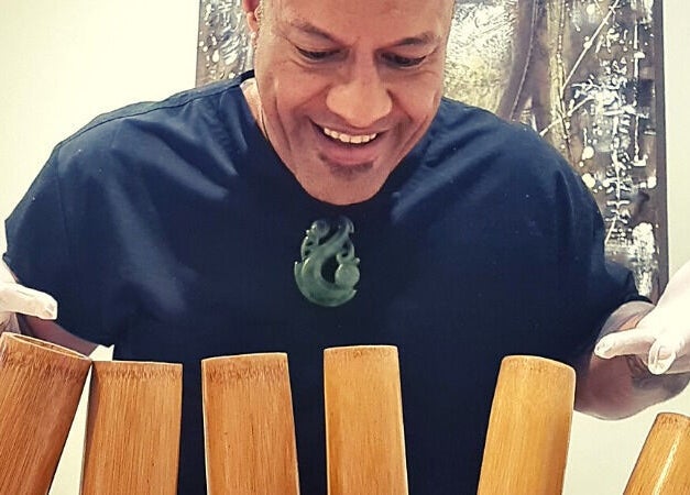 Therapist at Mana Physiques in South Toowoomba, Queensland, AU, preparing bamboo tools for a wellness session.
