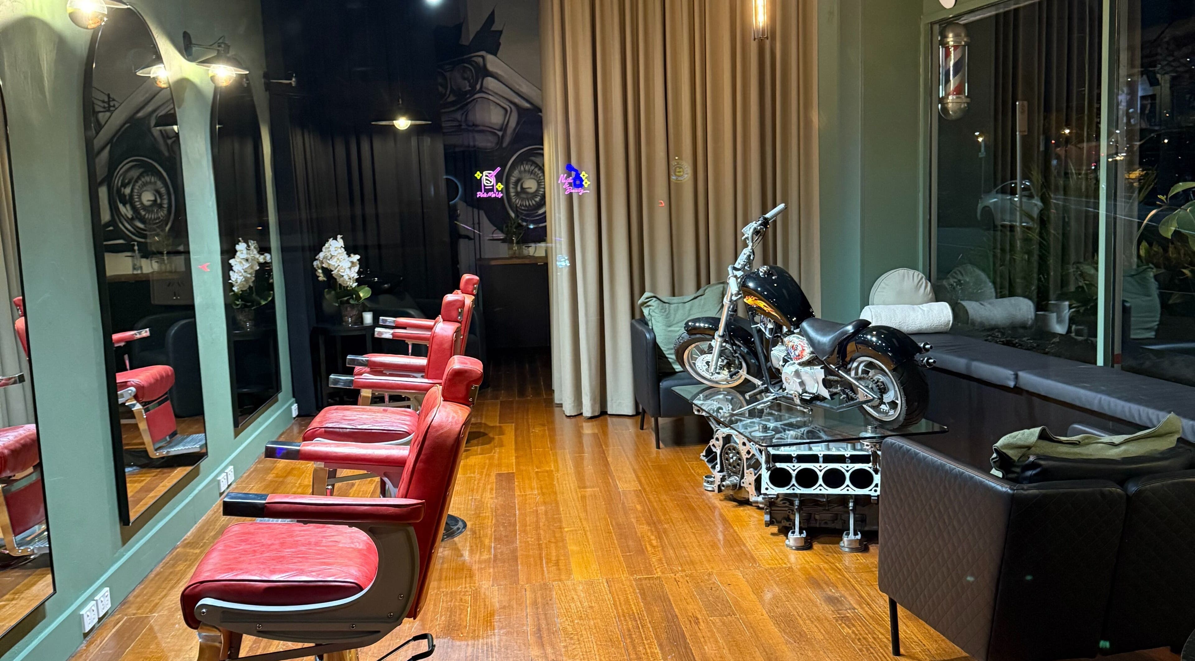 Interior of Mayhem Melbourne (Barbers) featuring red chairs and motorcycle decor in Melbourne, Victoria, AU.