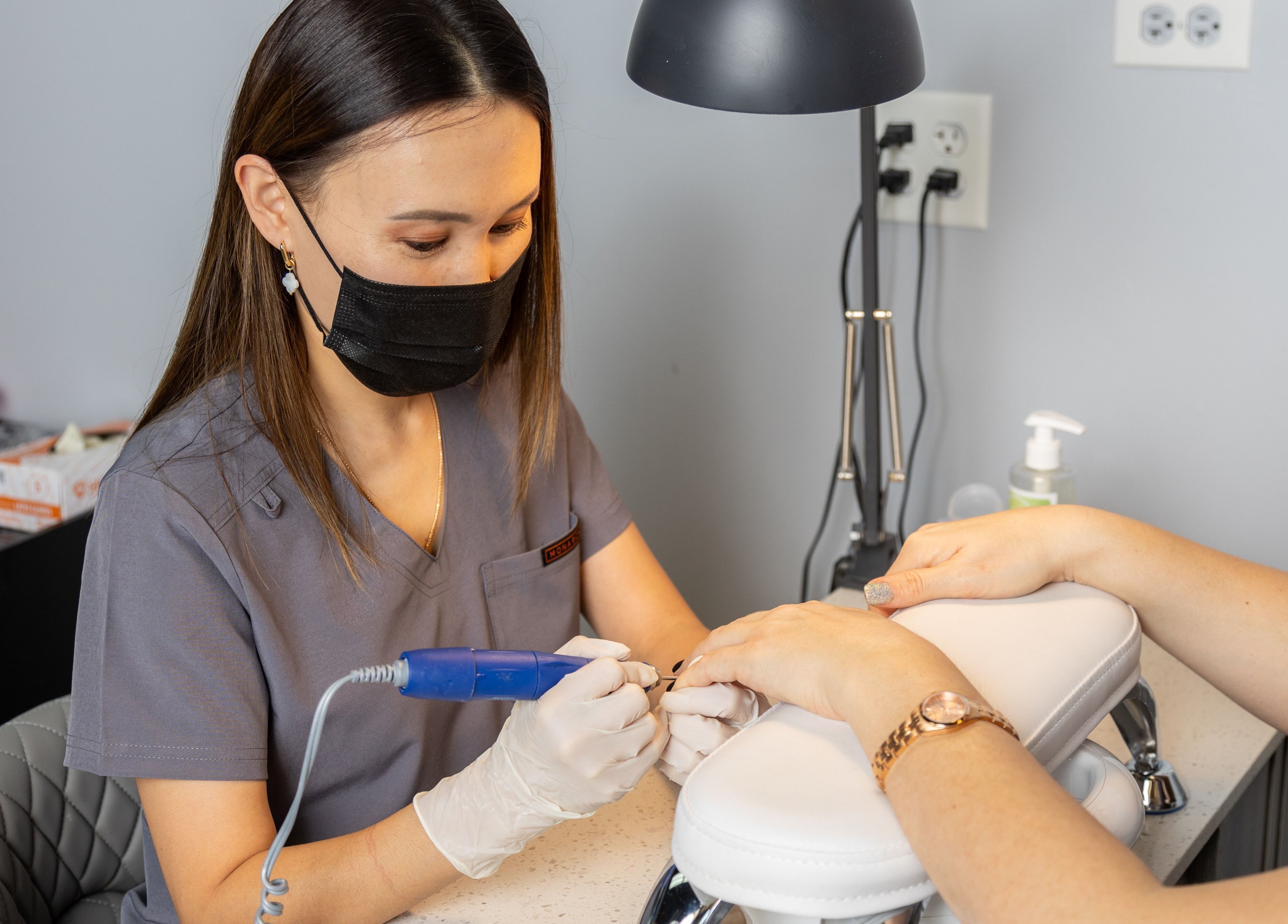 Manicurist at EG Nails & Spa in Naperville, Illinois, US, performing a professional nail service.
