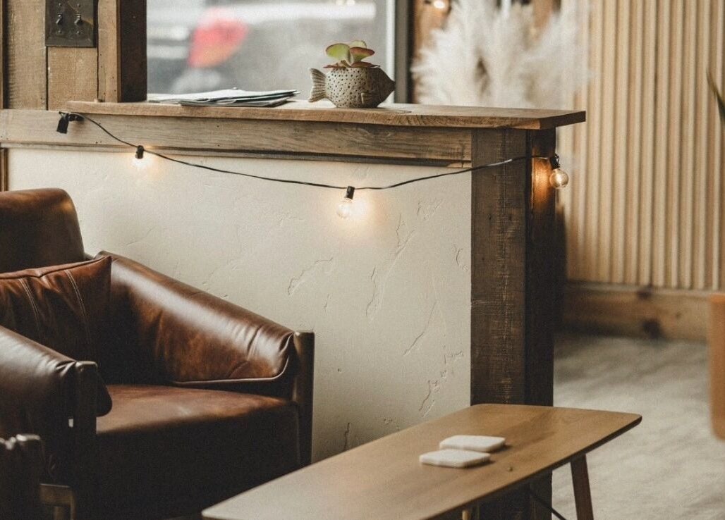 Chic seating area with string lights at Pura Vida Salon, Livingston, Montana, US.