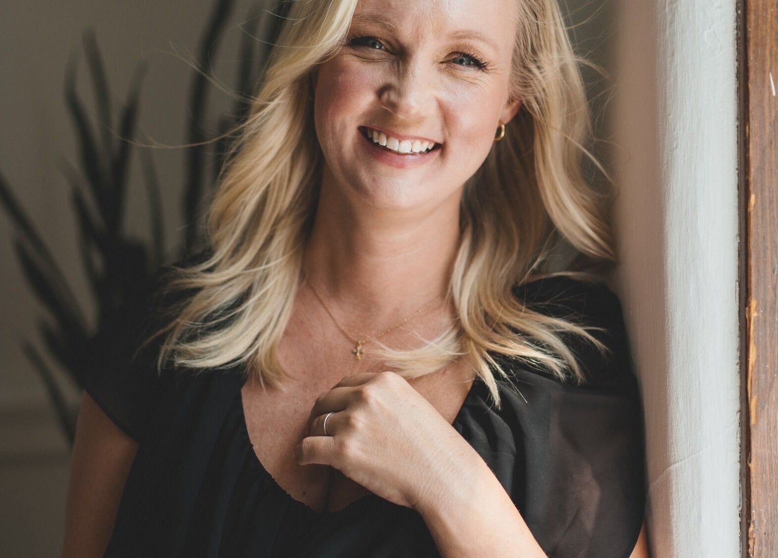Smiling woman with blonde hair at Pura Vida Salon, Livingston, Montana, US enjoying natural light.