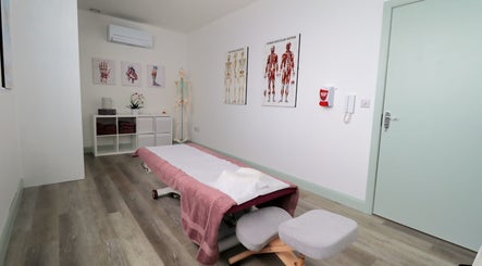 Therapy room at Myobody Balance in Drogheda, County Louth, IE with massage table and anatomy charts.