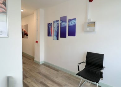 Modern waiting area at Myobody Balance, Drogheda, County Louth, IE with art and a sleek chair.