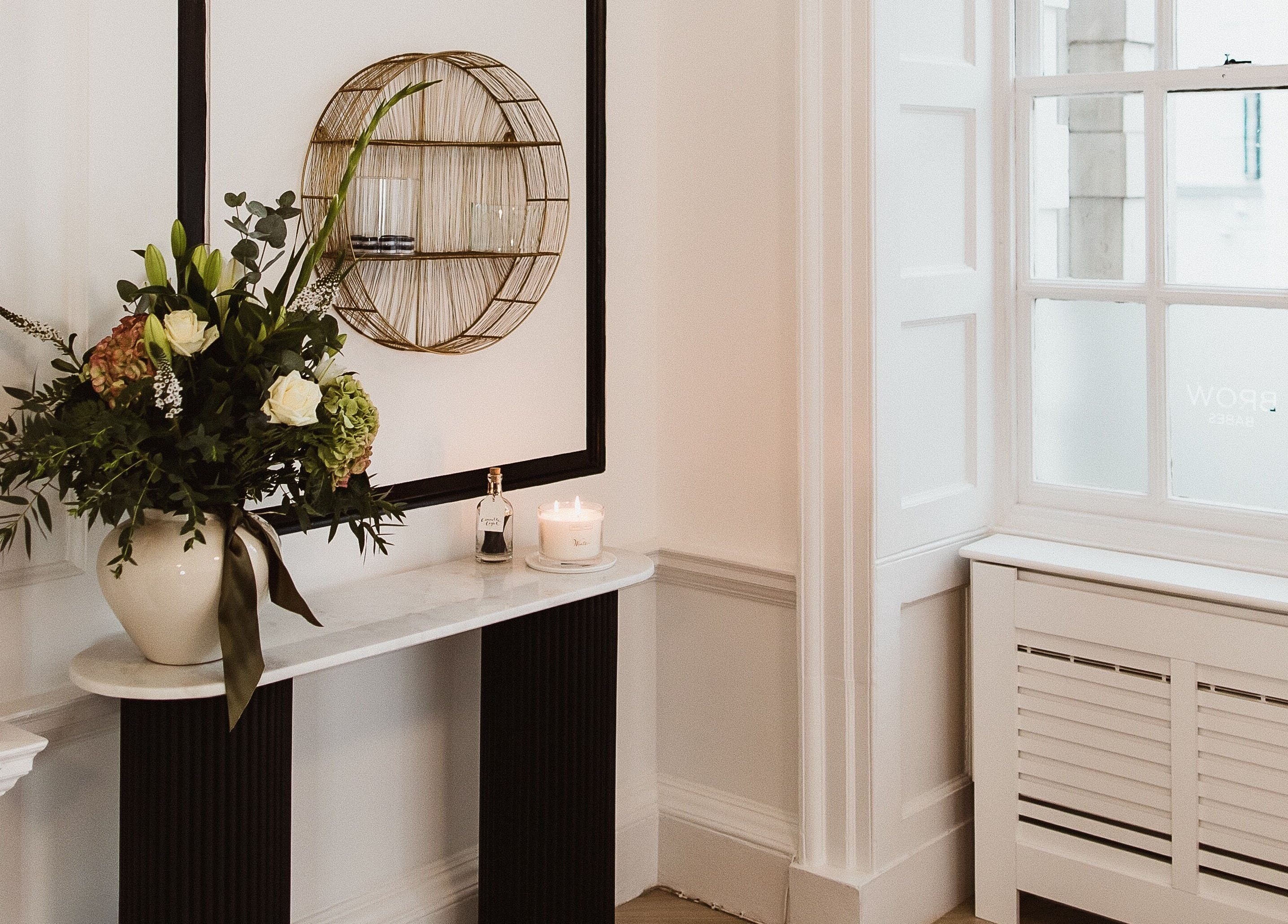 Elegantly decorated corner at BROW BABES - PHOEBE, Truro, England, GB featuring flowers and candle.