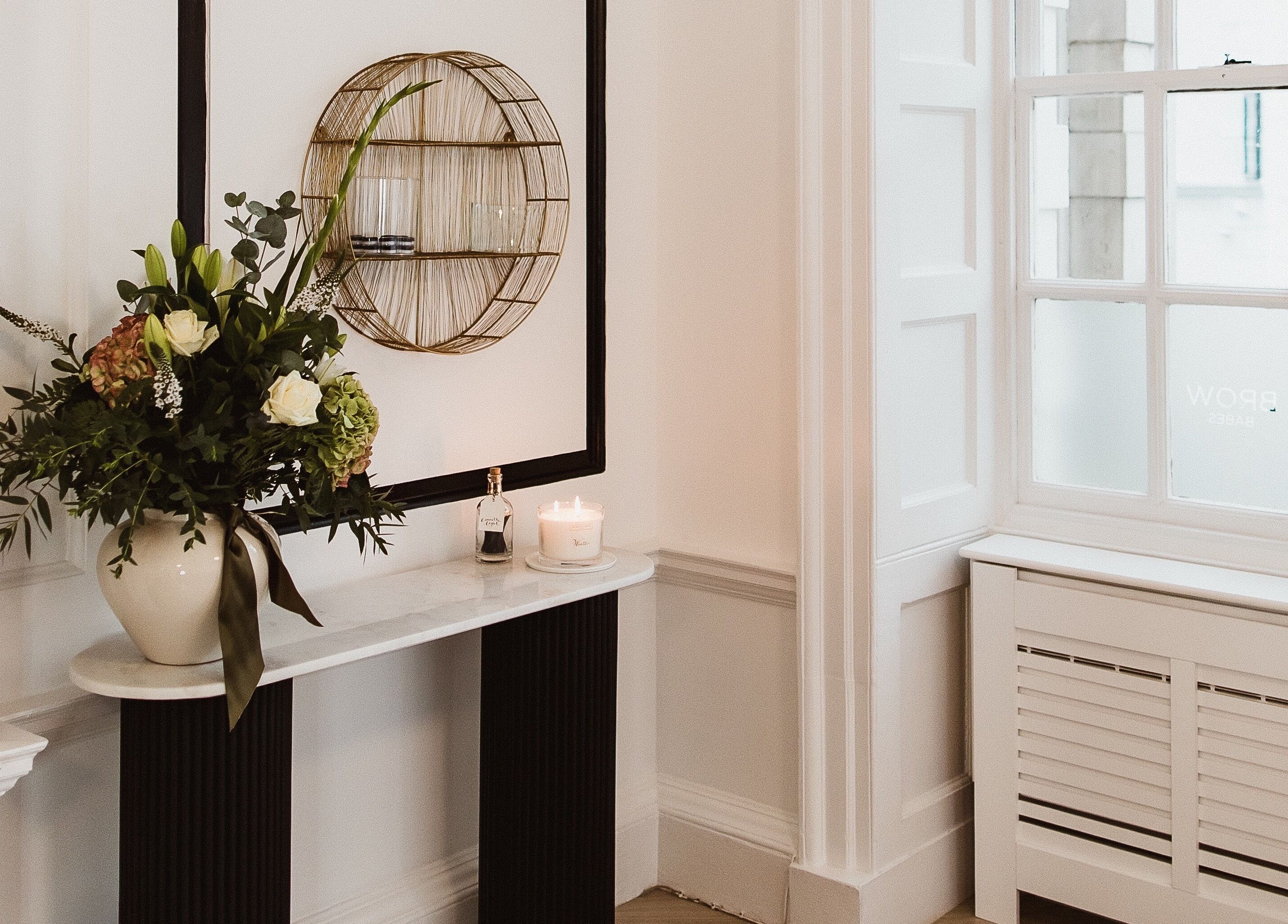 Elegantly decorated corner at BROW BABES - PHOEBE, Truro, England, GB featuring flowers and candle.