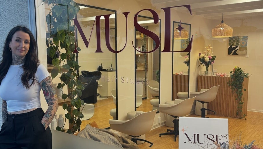 Inside view of Muse Hair Studio, Bay of Plenty, NZ showcasing sleek chairs and modern decor.