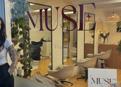 Inside view of Muse Hair Studio, Bay of Plenty, NZ showcasing sleek chairs and modern decor.