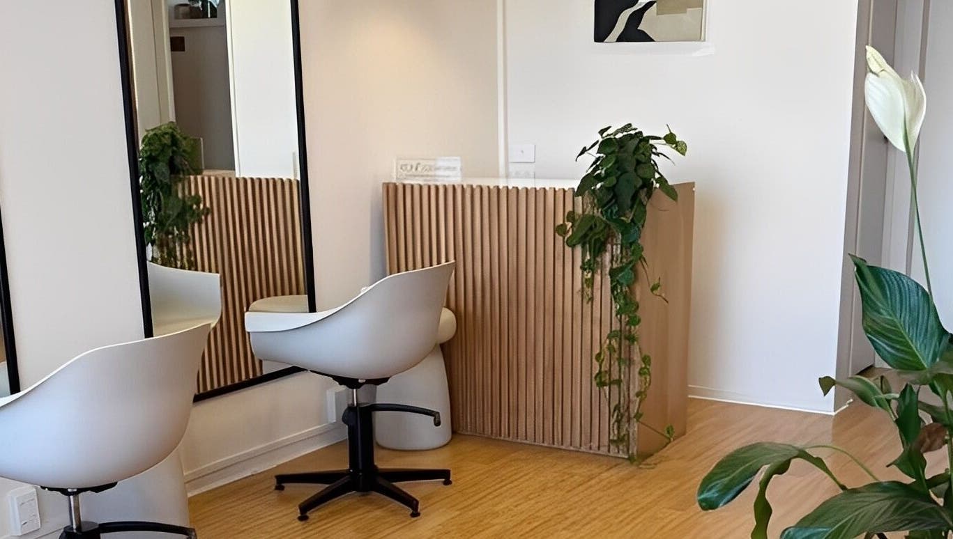 Modern, tranquil interior of Muse Hair Studio in Bay of Plenty, NZ, featuring sleek decor and lush plants.