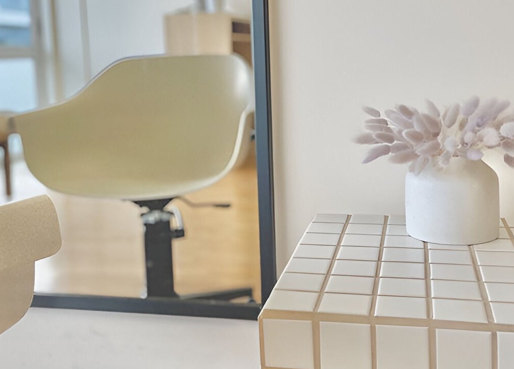 Elegant seating area in Muse Hair Studio, Bay of Plenty, NZ, with chic decor and a modern chair.