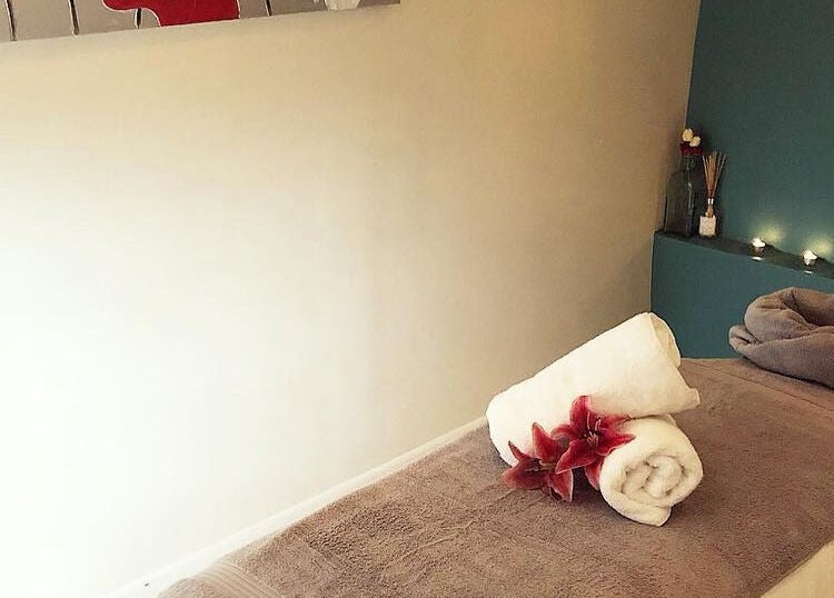 Relaxing massage room at Gloss Beauty Salon in Prestons, New South Wales, AU, with candles and soft towels.