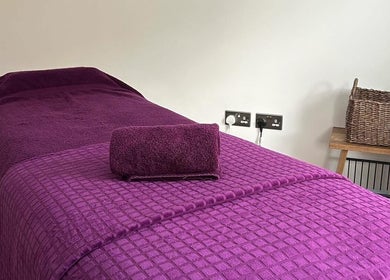 Orchard Holistic Therapy massage bed with purple linens in Waterlooville, England, GB for ultimate relaxation.