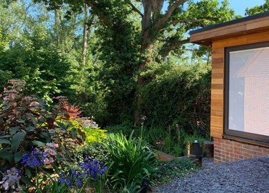 Orchard Holistic Therapy's tranquil garden at Waterlooville, England, GB, showcasing vibrant flowers and lush greenery.