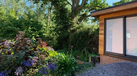 Orchard Holistic Therapy's tranquil garden at Waterlooville, England, GB, showcasing vibrant flowers and lush greenery.