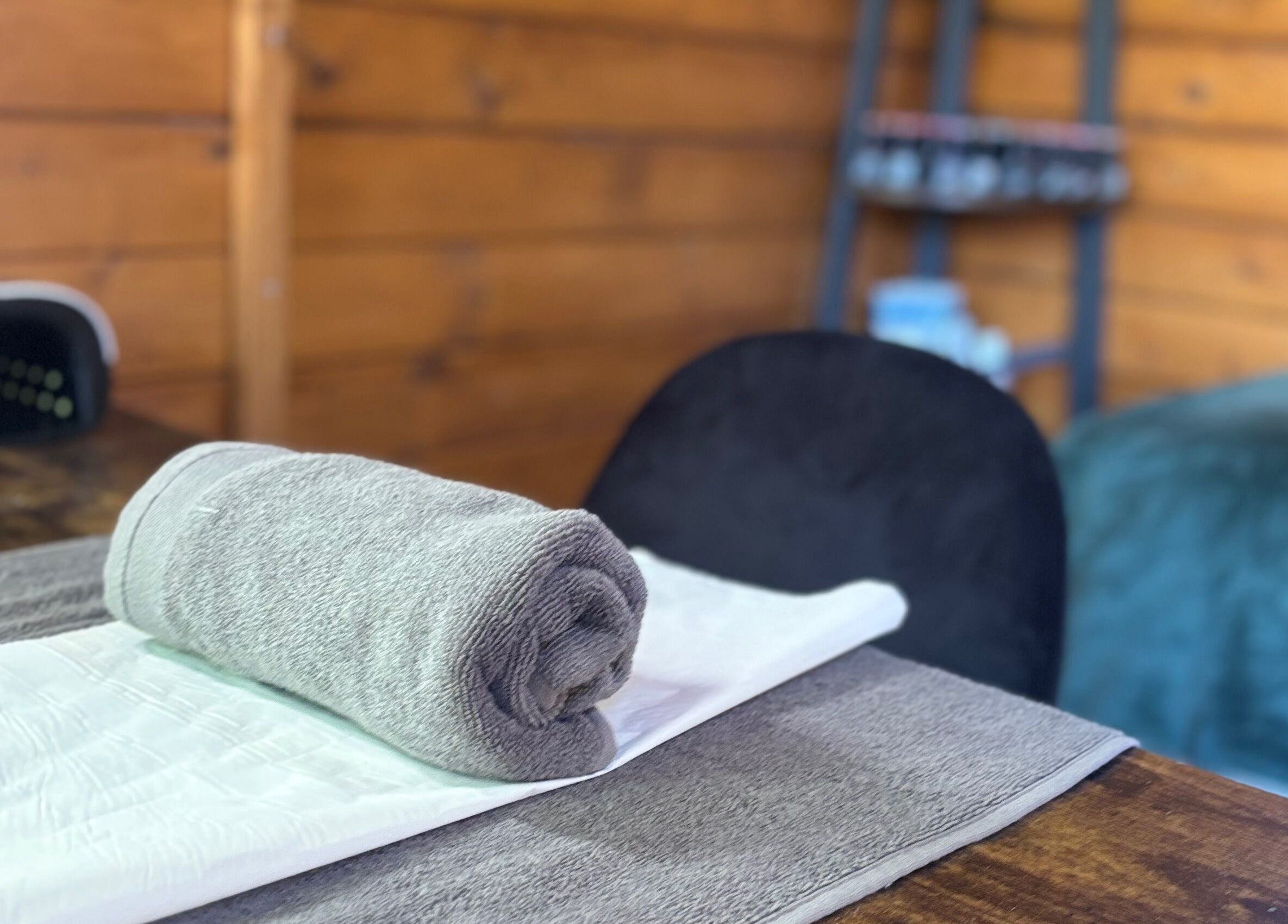 Cozy spa setup at Nails&Glow Beauty, Bristol, England, GB with plush towel on a wooden table.