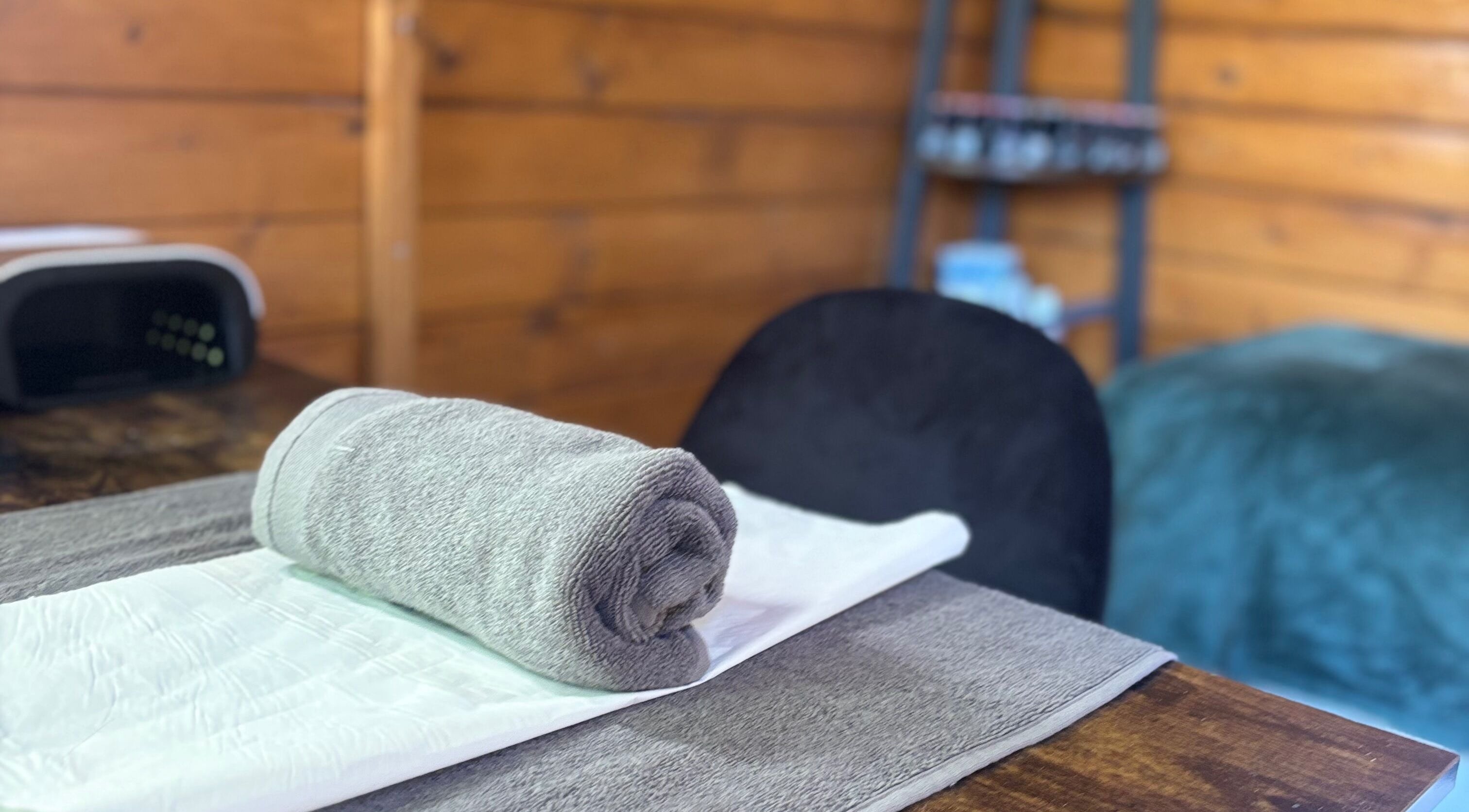 Cozy spa setup at Nails&Glow Beauty, Bristol, England, GB with plush towel on a wooden table.