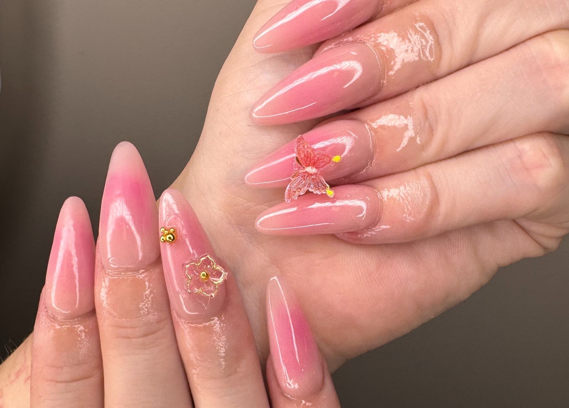 Elegant pink nail art with butterfly embellishments at The Lacquer Lounge in St. Catharines, Ontario, CA.