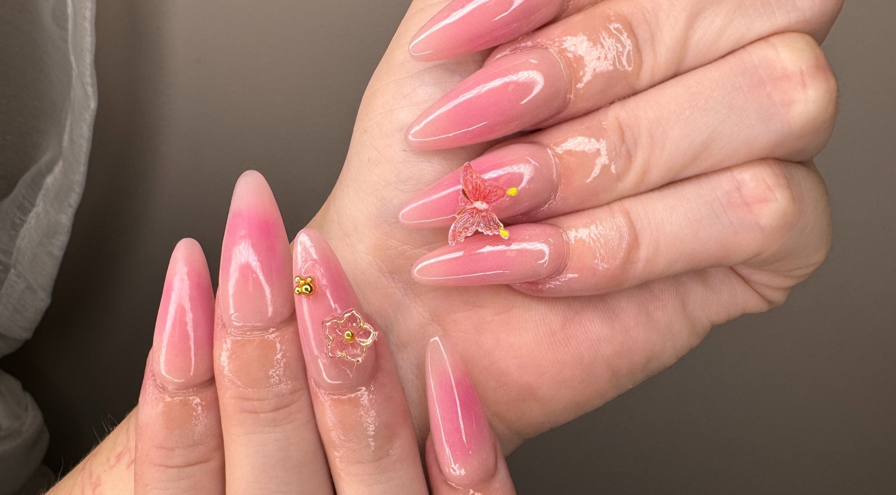 Elegant pink nail art with butterfly embellishments at The Lacquer Lounge in St. Catharines, Ontario, CA.