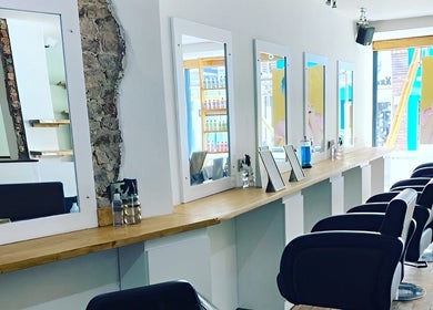 Stylish and modern salon interior at Associates Hair Winchester, Winchester, England, GB with chic mirrors and chairs.