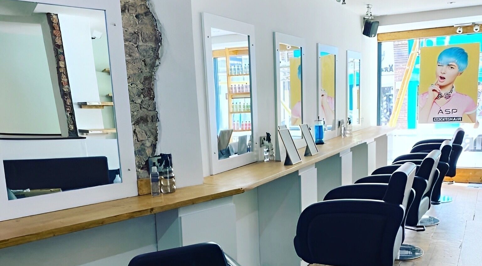 Stylish and modern salon interior at Associates Hair Winchester, Winchester, England, GB with chic mirrors and chairs.