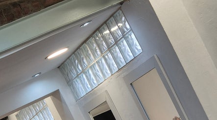 Stylish glass block wall at Associates Hair Winchester, Winchester, England, GB, enhancing the sleek interior.