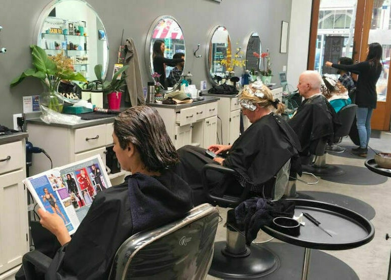 Customer relaxing at Maxi Hair Salon in Berkeley, California, US with stylish interior and attentive service.