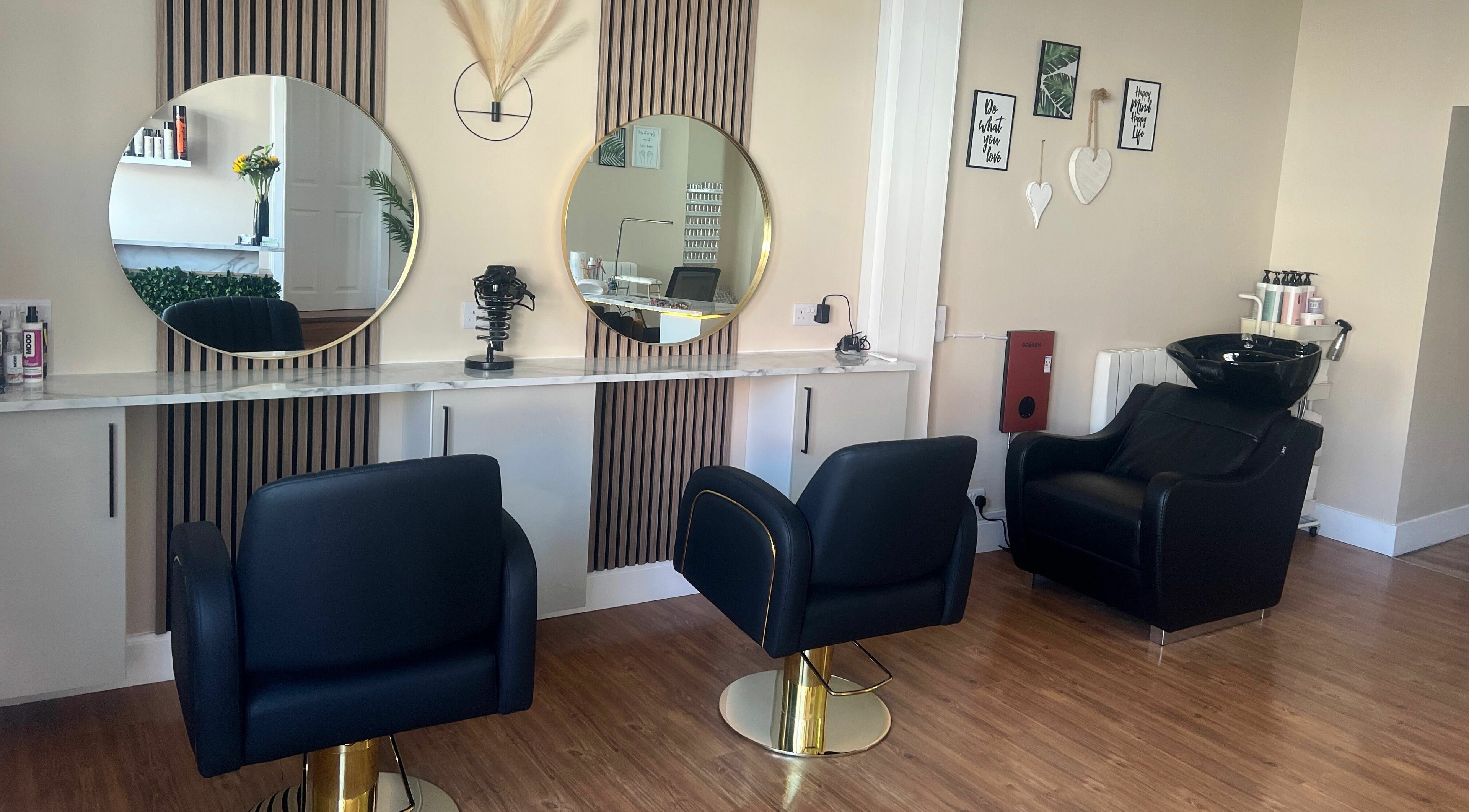 Modern salon interior at Jc Hair and Nail Room, Saint Monans, Scotland, with elegant black chairs and round mirrors.