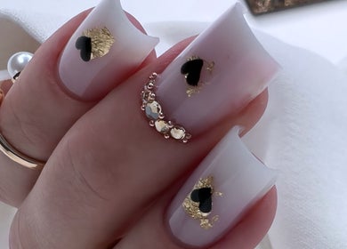 Stylish nail art with black hearts and gold flakes at Silvia Vasiliu Nails, STOKE-ON-TRENT, England, GB.