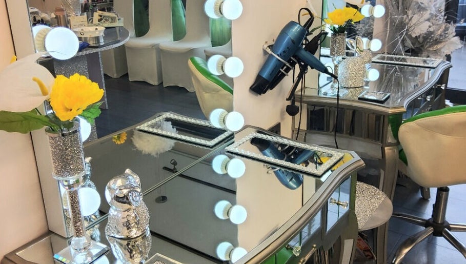 Elegant salon vanity at Need a Makeover Hair, Dudley, England, GB, with flowers and mirror lights.