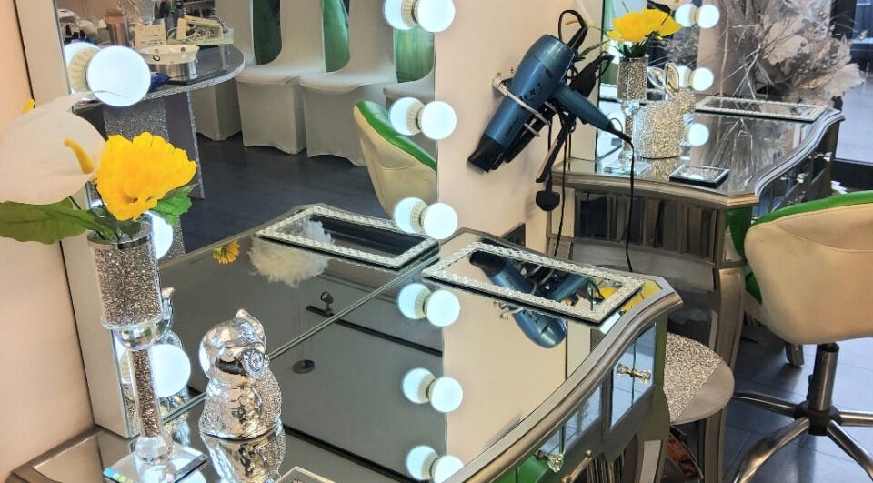 Elegant salon vanity at Need a Makeover Hair, Dudley, England, GB, with flowers and mirror lights.