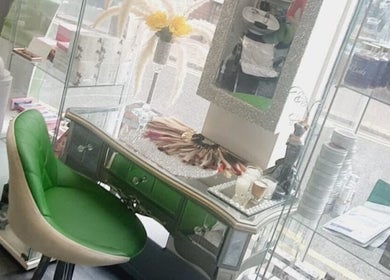 Chic vanity setup at Need a Makeover Hair in Dudley, England, GB with green chair and beauty products.