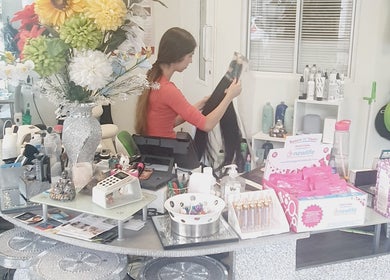 Colorful salon counter at Need a Makeover Hair, Dudley, England, GB with stylist organizing hair products.