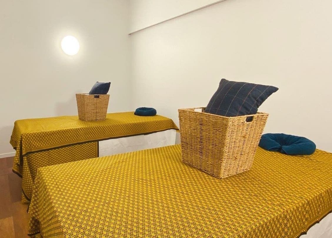 Relaxing massage room at Tawee Thai Massage and Spa, Auckland, NZ, featuring cozy tables and wicker baskets.