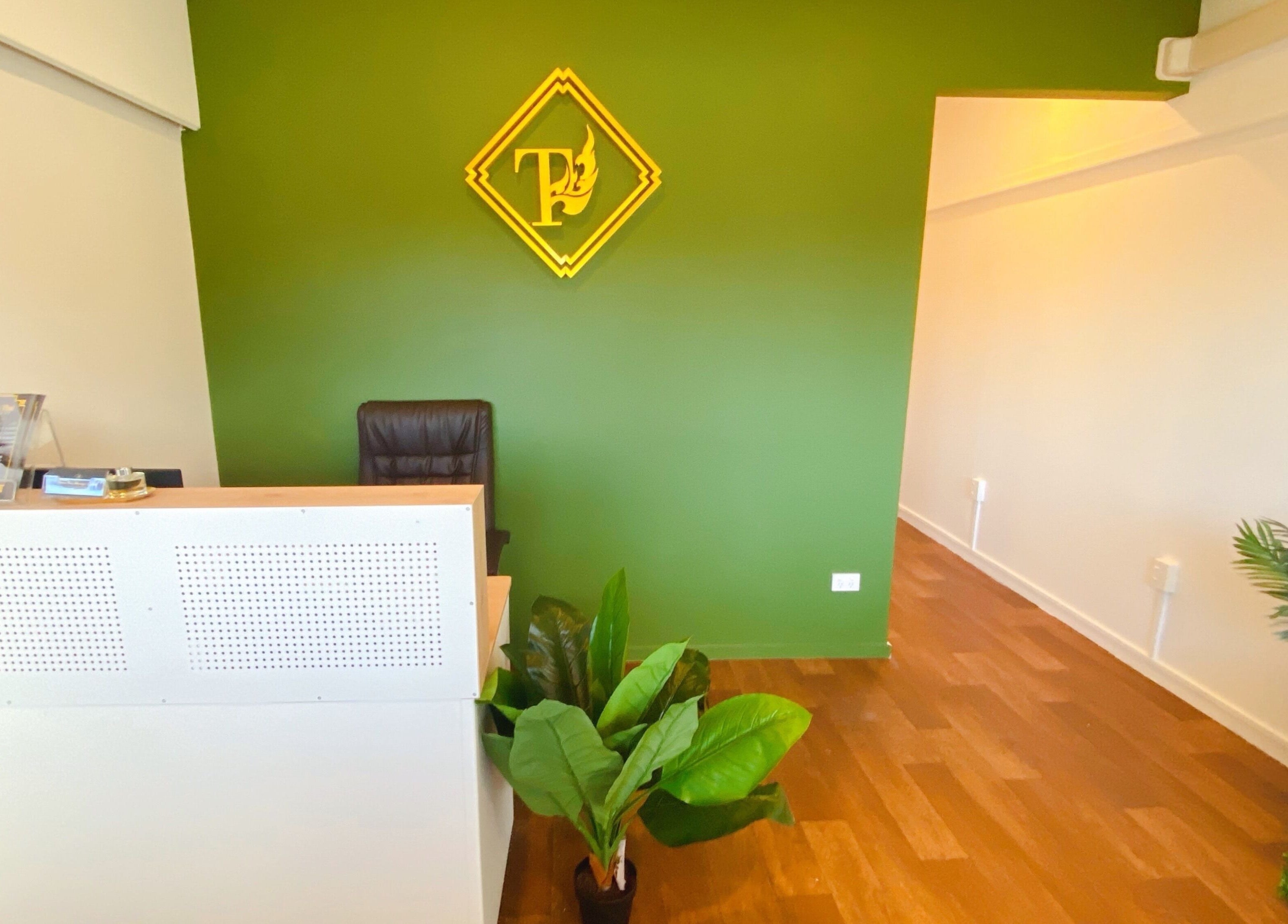 Reception of Tawee Thai Massage and Spa in Auckland, NZ with green walls and plants.