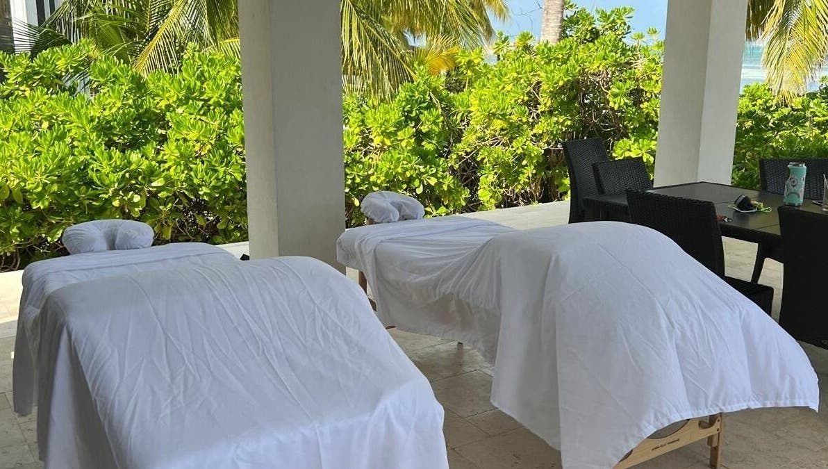Open-air massage beds at Molly's Hair and Spa Cayman in Grand Cayman, KY, surrounded by lush greenery.