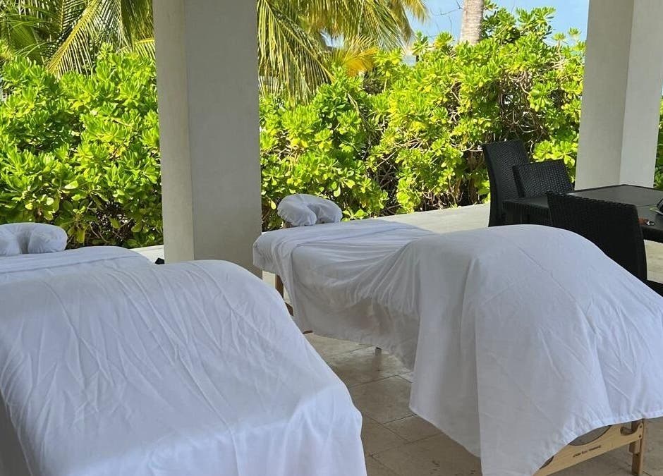 Open-air massage beds at Molly's Hair and Spa Cayman in Grand Cayman, KY, surrounded by lush greenery.