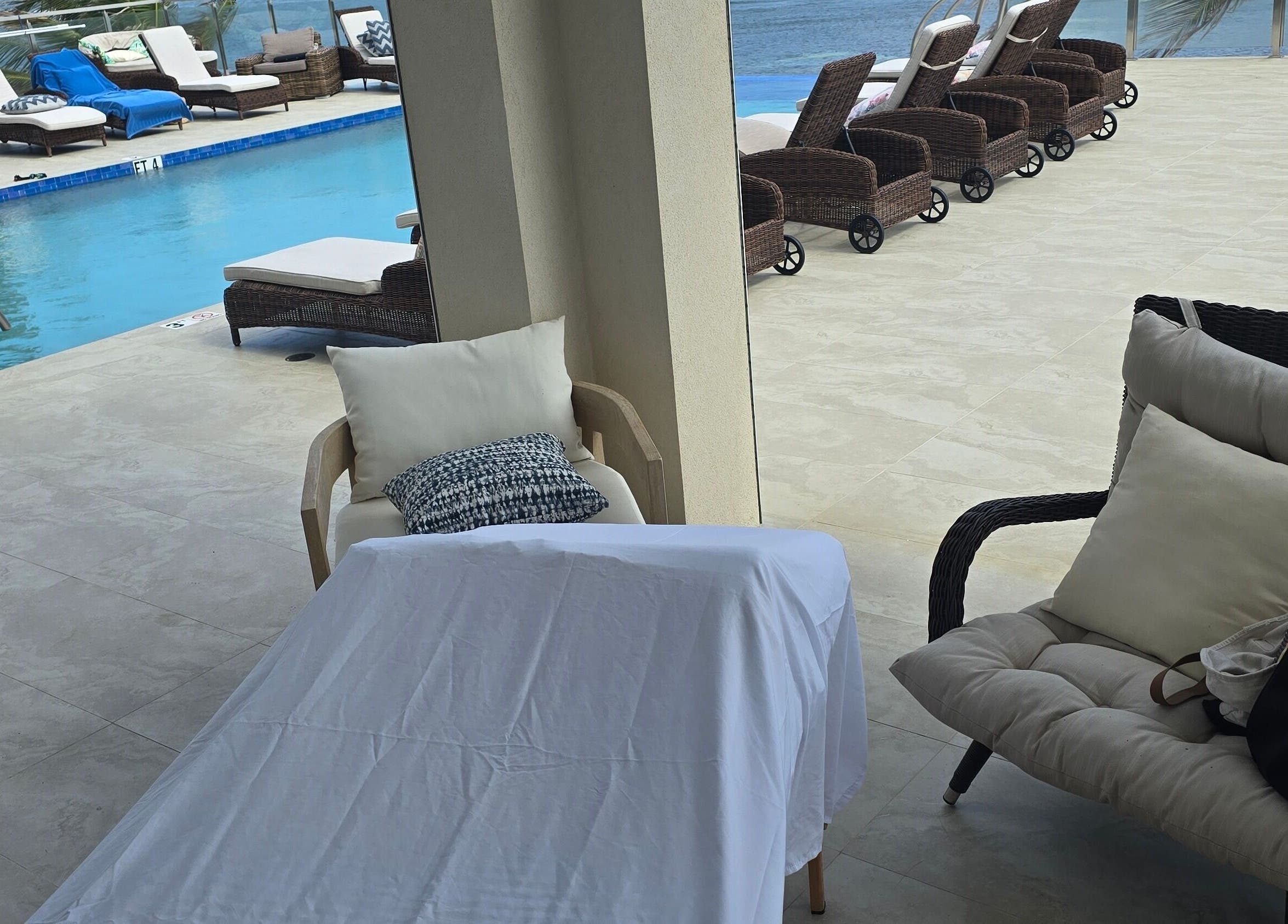 Relaxing poolside view at Molly's Hair and Spa Cayman, Grand Cayman, KY with lounge chairs and oceanfront.