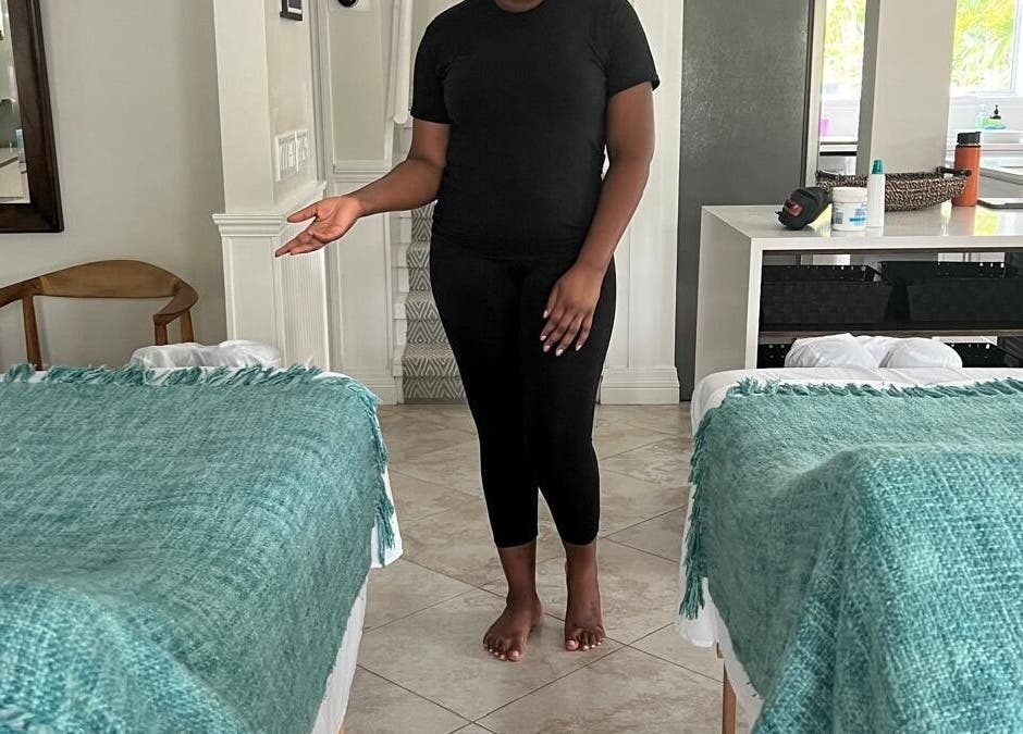 A welcoming massage room at Molly's Hair and Spa Cayman, Grand Cayman, KY, featuring two teal-covered beds.