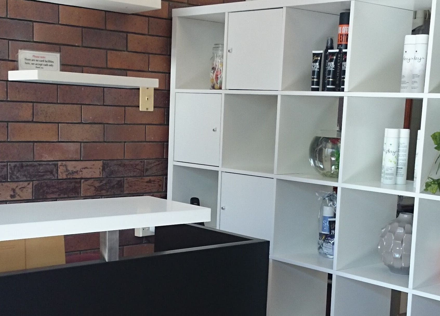 Modern white shelving at Maxine's Hair Care in Kallangur, Queensland, AU, displaying hair products and decor.