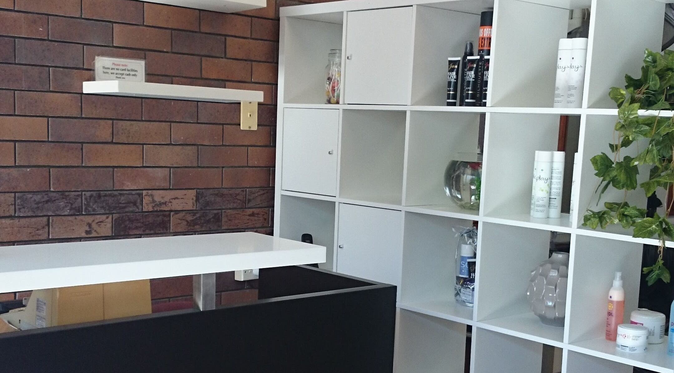 Modern white shelving at Maxine's Hair Care in Kallangur, Queensland, AU, displaying hair products and decor.