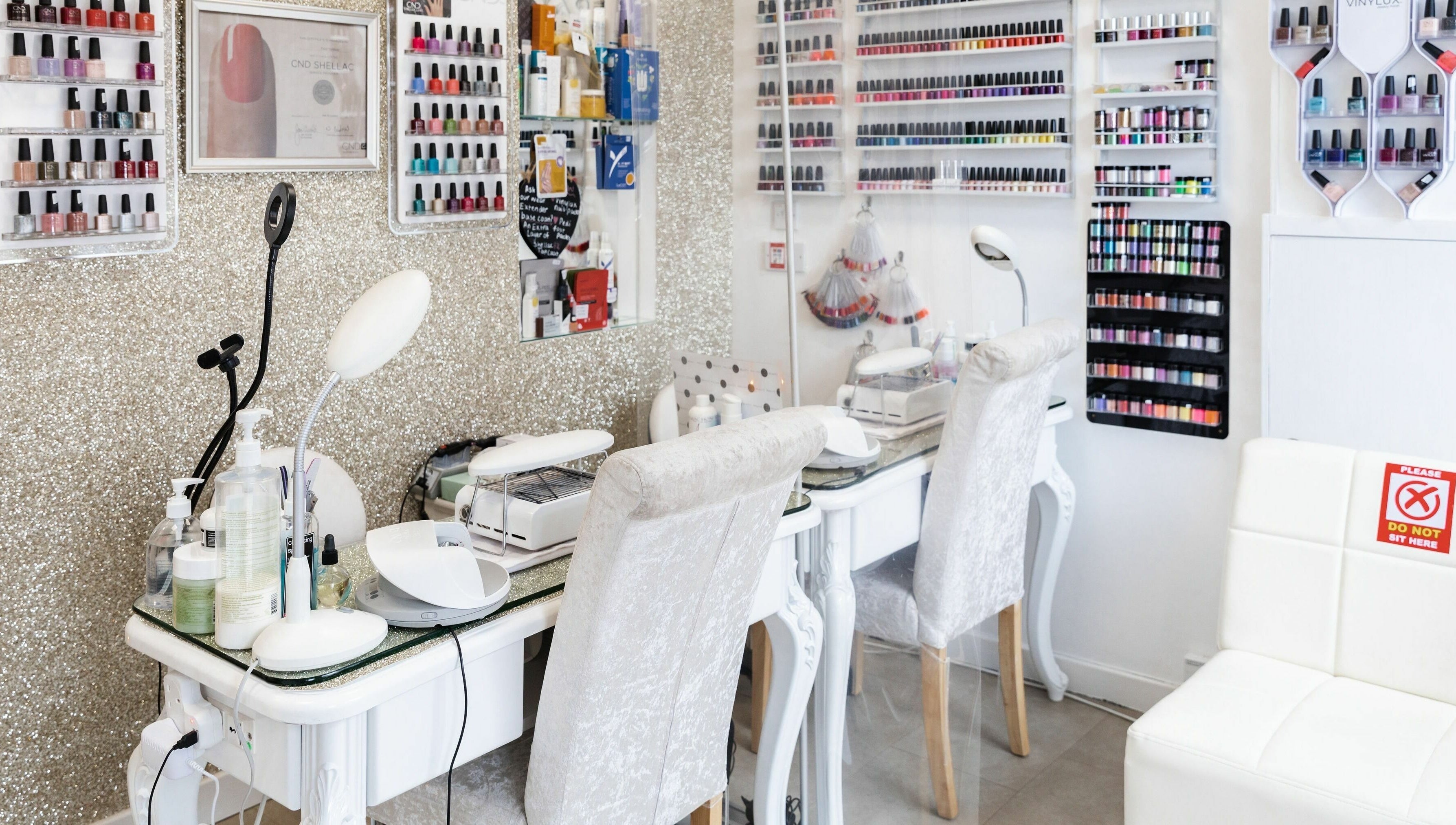 Interior of Pallas Beauty nail salon in Dundee, Scotland, GB with manicure stations and polish displays.