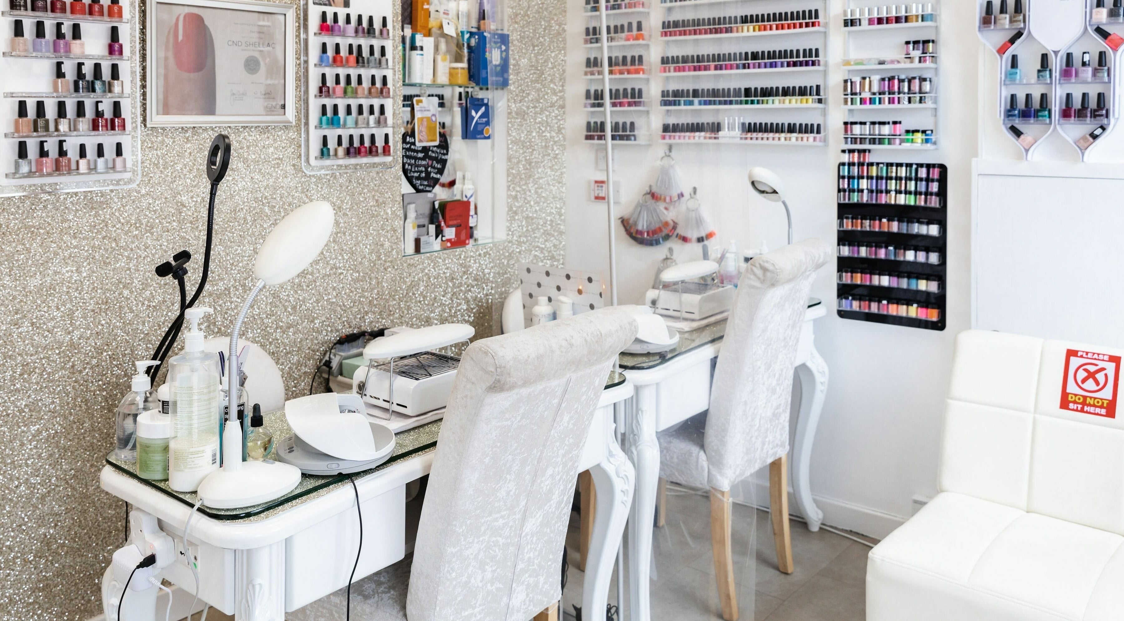 Interior of Pallas Beauty nail salon in Dundee, Scotland, GB with manicure stations and polish displays.