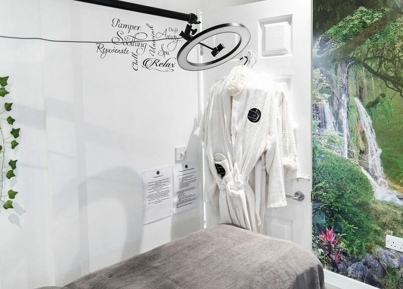 Tranquil treatment room with nature mural at Pallas Beauty, Dundee, Scotland, GB, featuring robes and lush decor.
