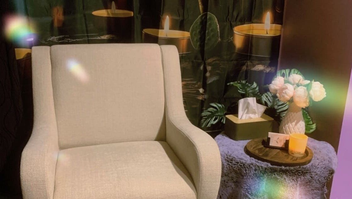 Cozy chair with flowers and candles at CamelliasBodyMassage, Christchurch, NZ for a peaceful ambiance.