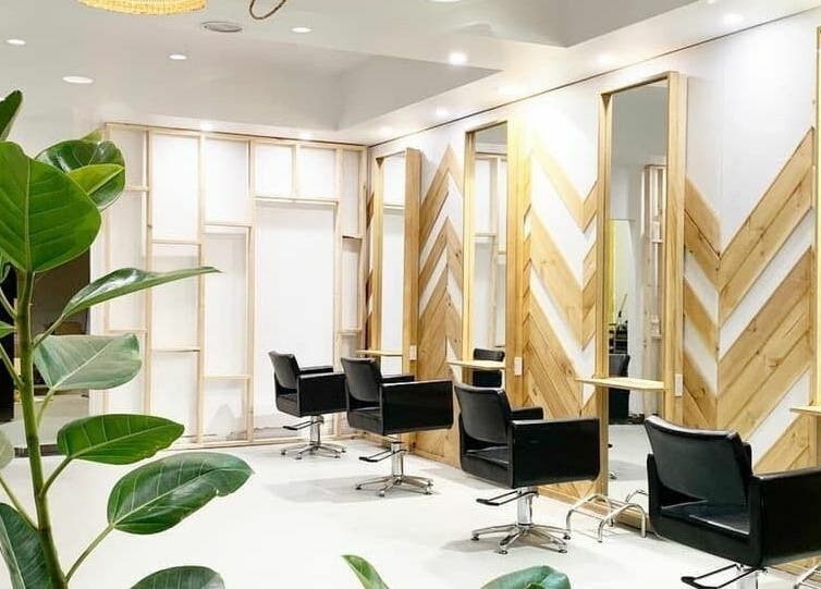 Stylish interior of The Vine Hairstylist in Melbourne, Victoria, AU featuring sleek black chairs and natural decor.