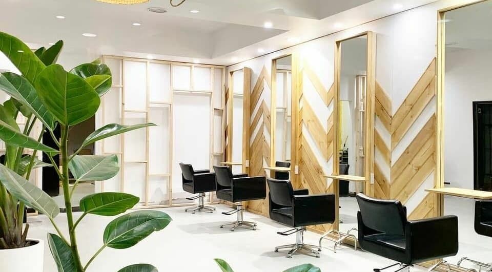 Stylish interior of The Vine Hairstylist in Melbourne, Victoria, AU featuring sleek black chairs and natural decor.