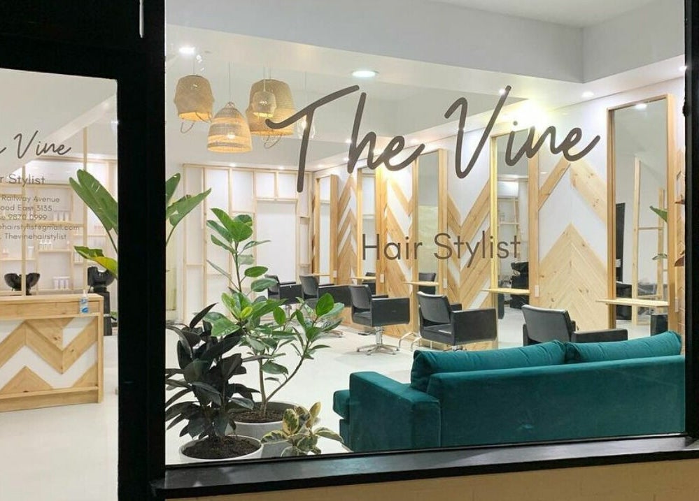 The Vine Hairstylist interior in Melbourne, Victoria, AU, featuring sleek chairs and modern wooden decor.