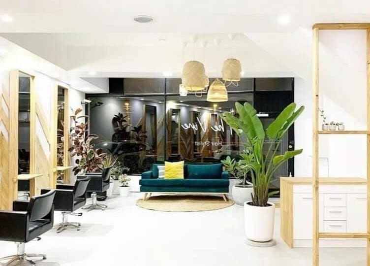 Modern interior of The Vine Hairstylist in Melbourne, Victoria, AU, featuring sleek seating and lush plants.
