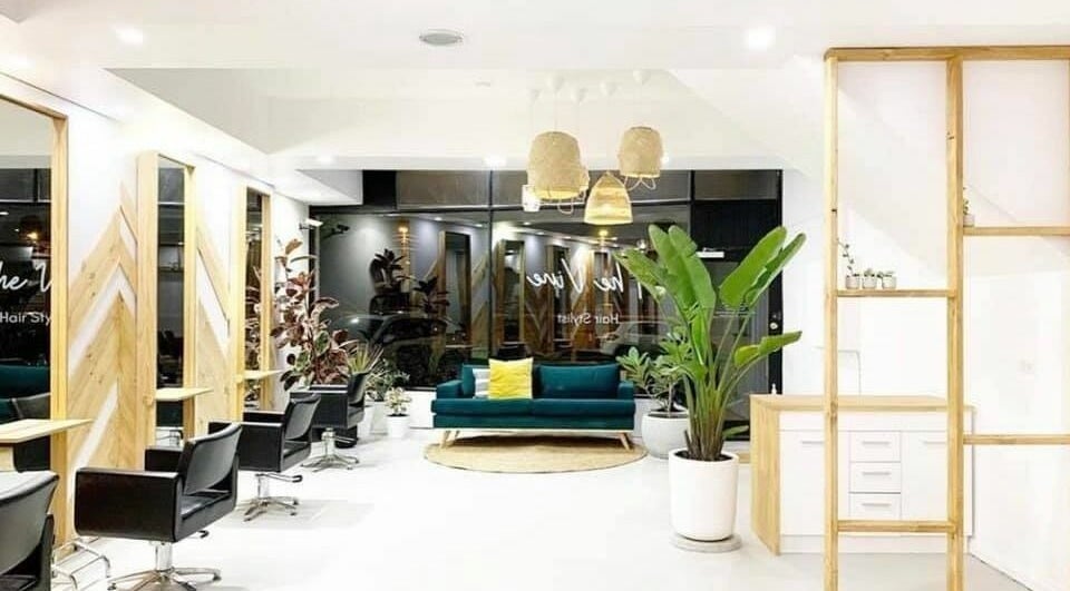 Modern interior of The Vine Hairstylist in Melbourne, Victoria, AU, featuring sleek seating and lush plants.