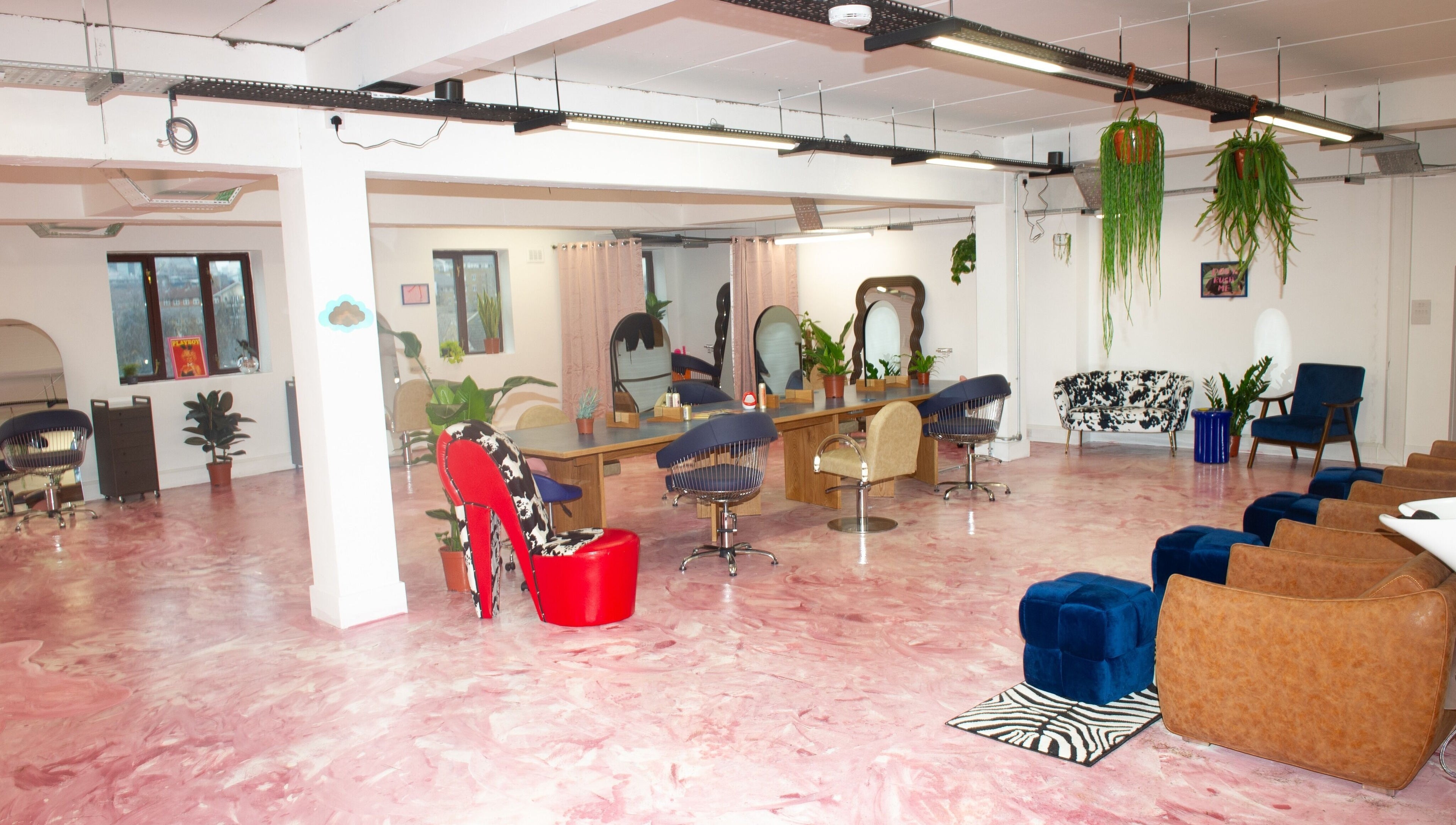 Spacious salon interior at Shag East in London, England, GB with modern chairs and pink marbled floor.