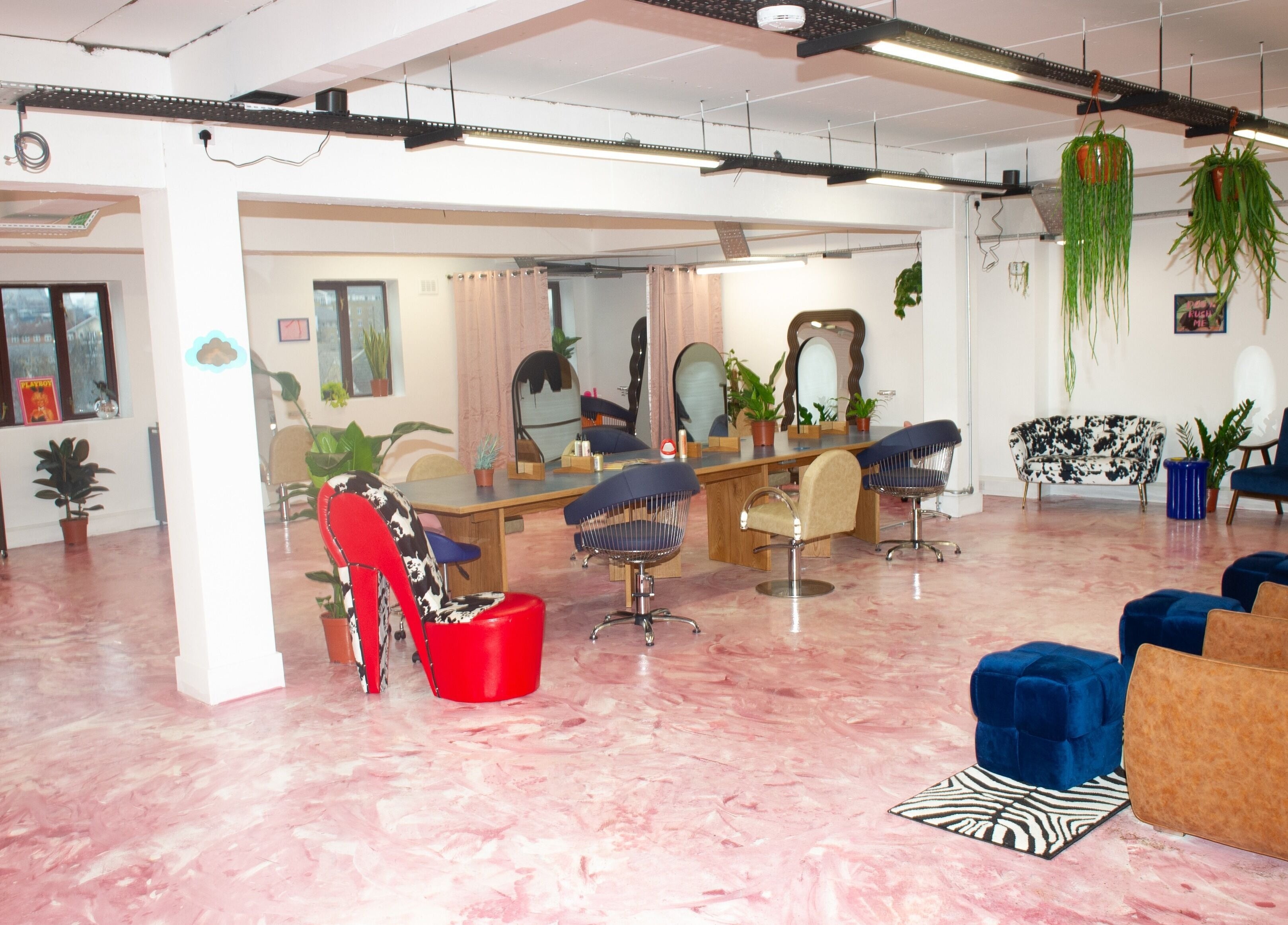 Spacious salon interior at Shag East in London, England, GB with modern chairs and pink marbled floor.